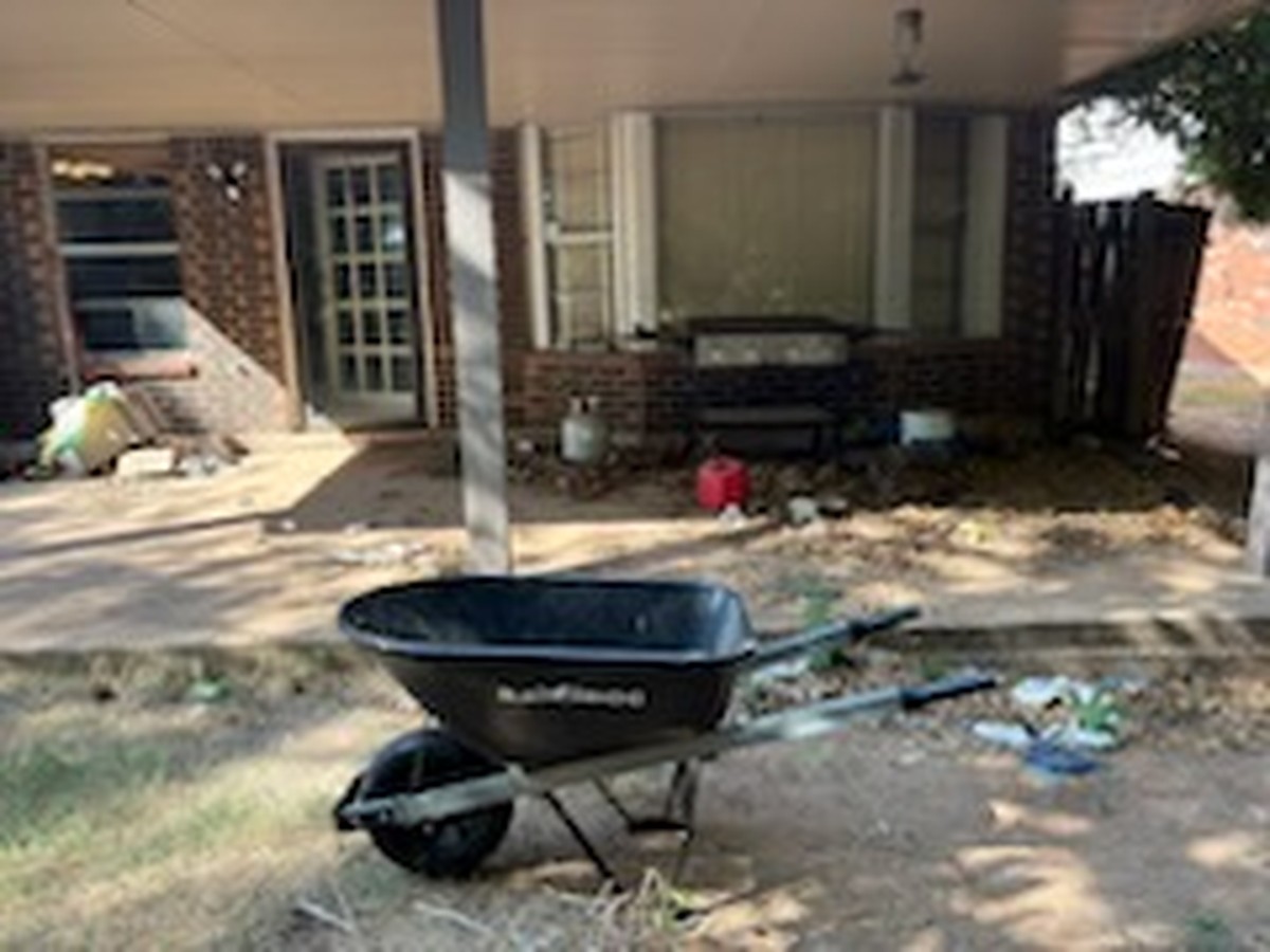 Cluttered back patio before a move-out cleanout in Oklahoma City
